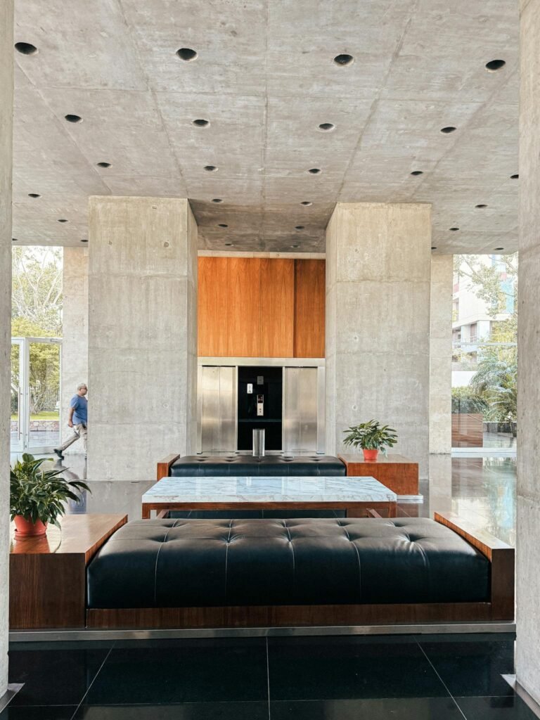 Contemporary lobby with modern furniture and plants in a Buenos Aires building.